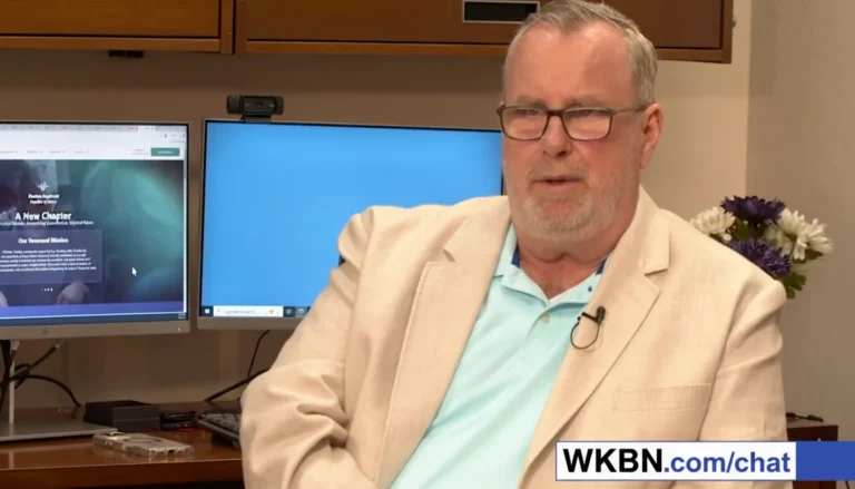 Man in beige blazer discussing website content.